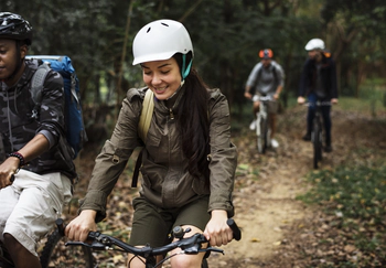 Group of friends ride mountain bike in the forest together