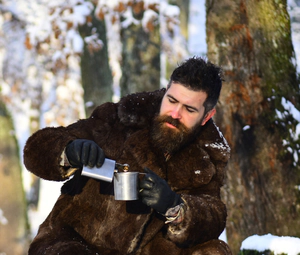 Man drinks alcohol in a cold winter forest